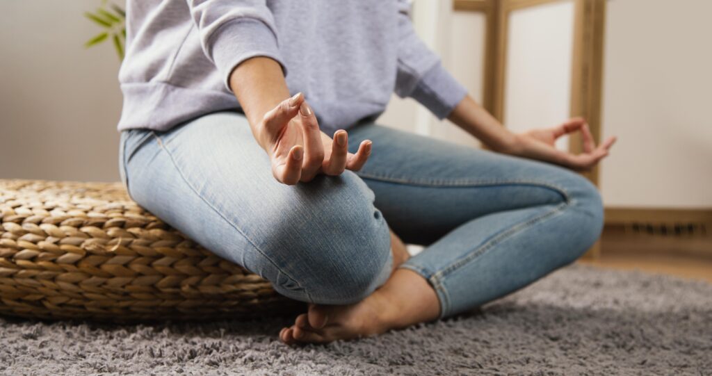 Persona practicando meditación para principiantes en casa, postura relajada y ambiente tranquilo